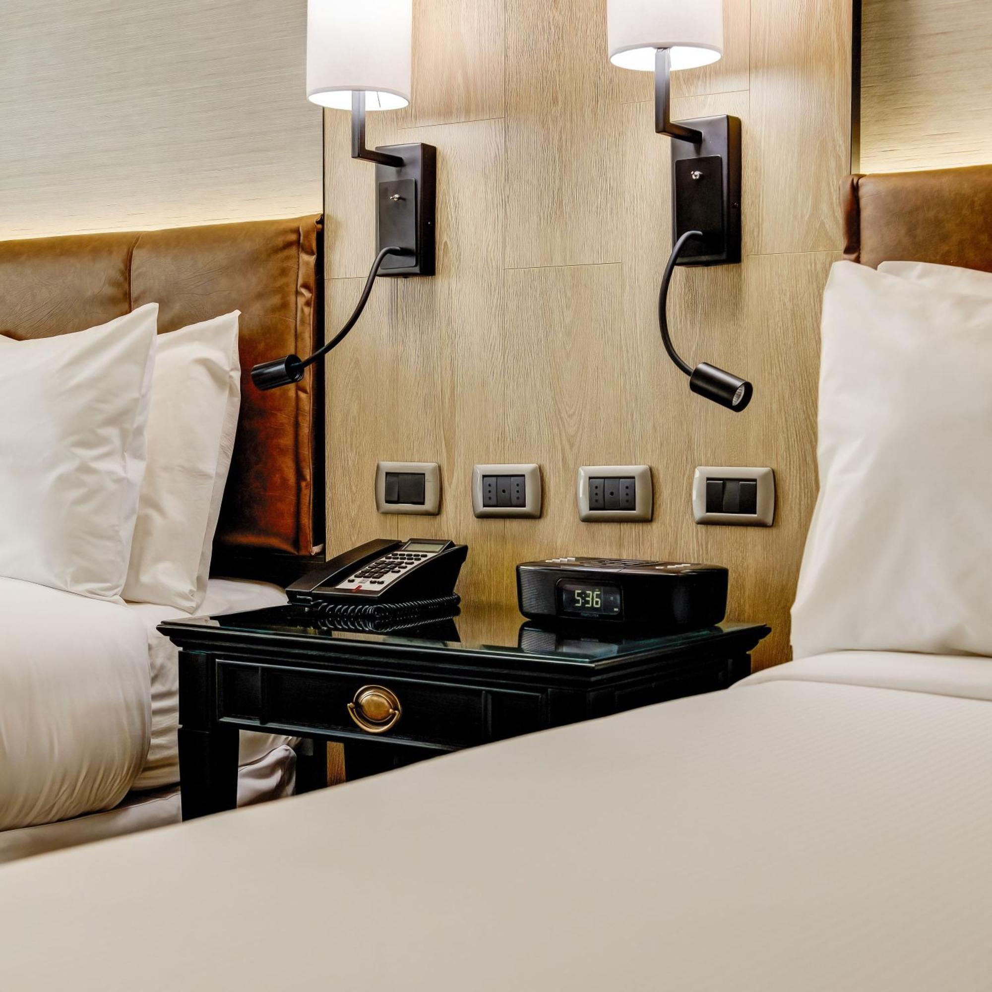 Plaza El Bosque Ebro Otel Santiago Dış mekan fotoğraf A bedside table with a telephone and a digital alarm clock
